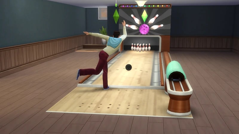 A Sim stands with one leg up in the air after throwing a bowling ball down a lane towards some bowling pins.
