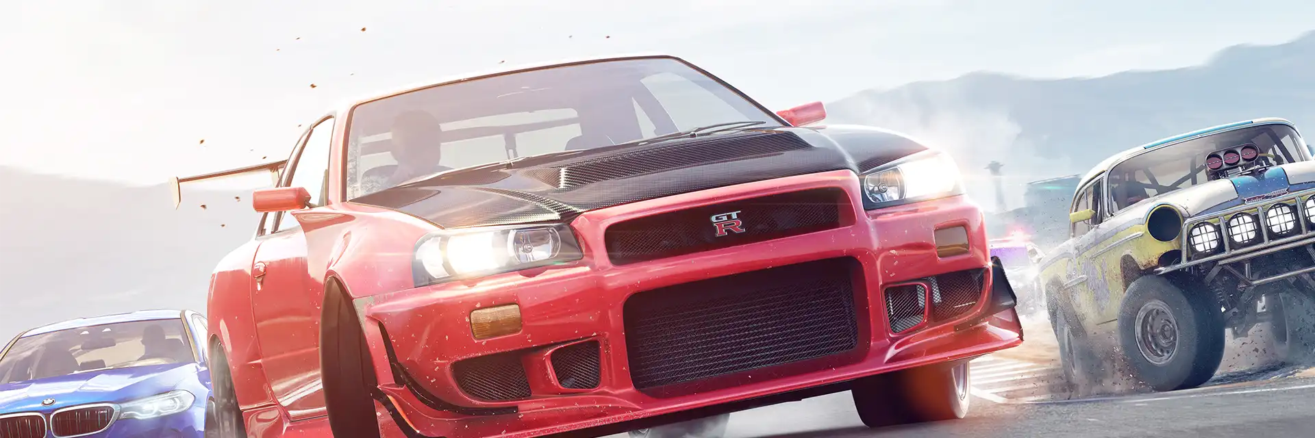 A red sports car races between a blue car and an off-road vehicle on a dusty road.