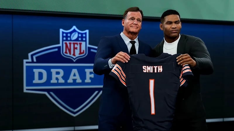 Draft player holding a number 1 jersey on stage with the NFL Commissioner.