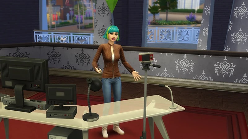 A blue-haired Sim in a brown jacket and blue jeans stands behind a desk recording a video on a camera.