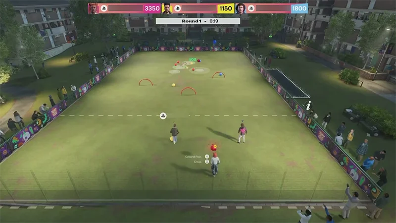 Players compete in a nighttime bocce ball Kickabout, aiming colored balls toward targets on the pitch.