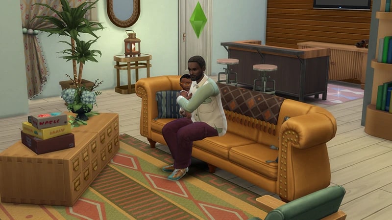 A Sim sits on a sofa holding an infant. In front of them sits a coffee table with a plant and a stack of puzzles.